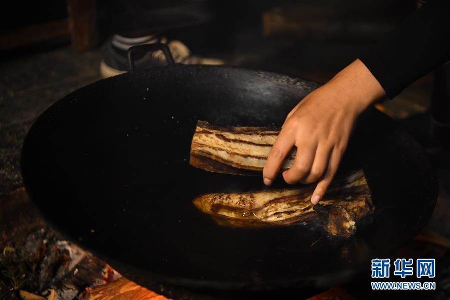 施林娇在直播中煮腊肉，为炒腊肉做准备（4月23日摄）。