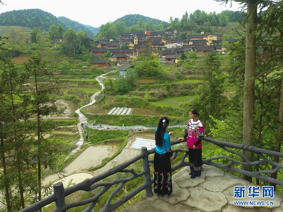 施林娇（右）在十八洞村和老师学习唱苗歌（4月23日摄，无人机照片）。