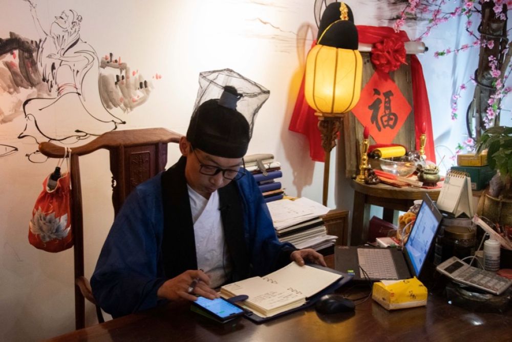 ↑“星汉庭”汉服店负责人曾晓武在处理线上订单（4月25日摄）。