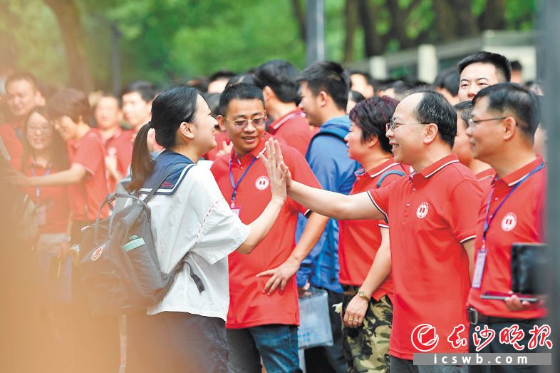 2019年高考考场外，考生与送考者击掌。资料照片