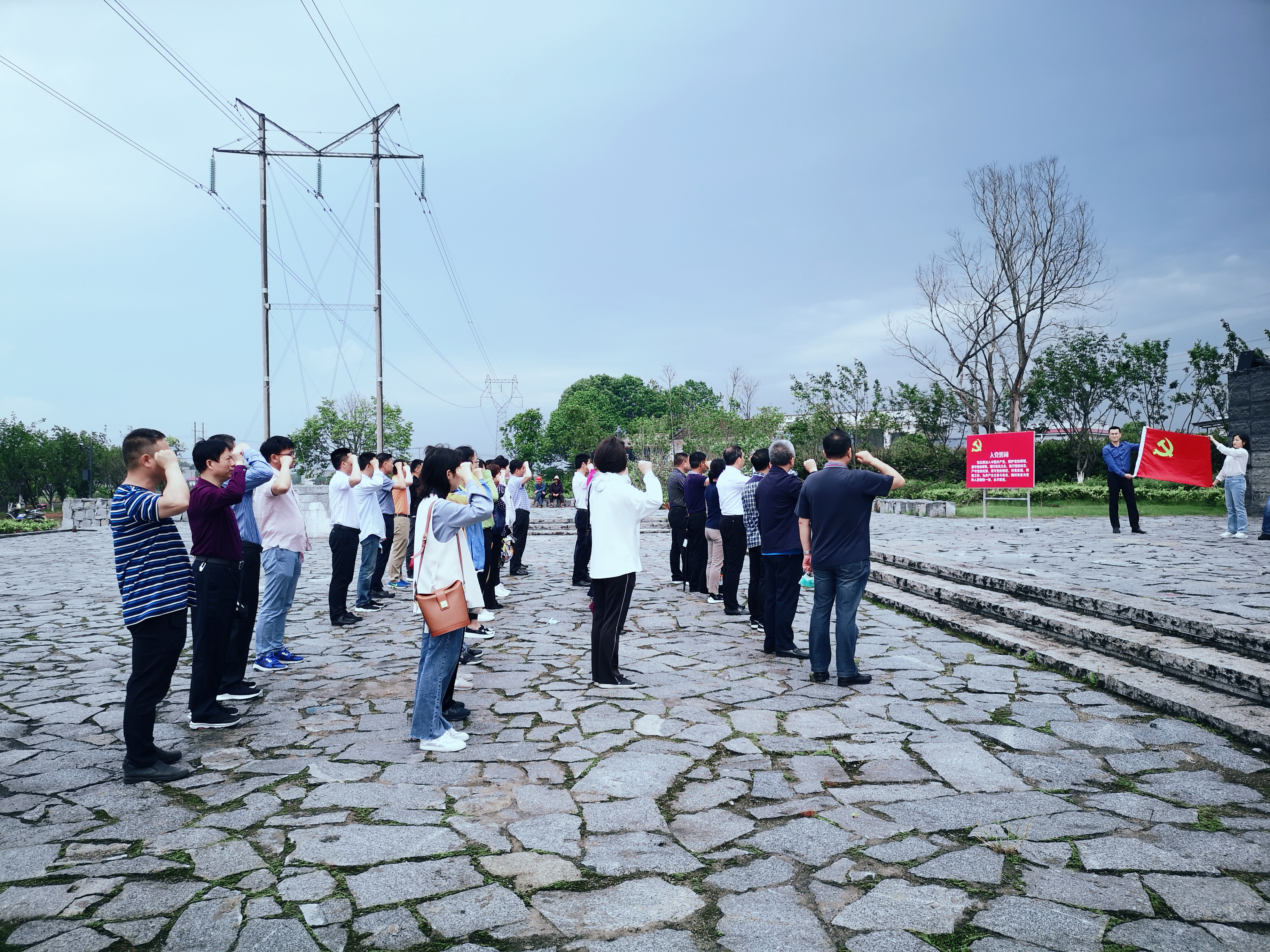 党员干部在鲜艳的党旗下，高举右拳，重温入党誓词