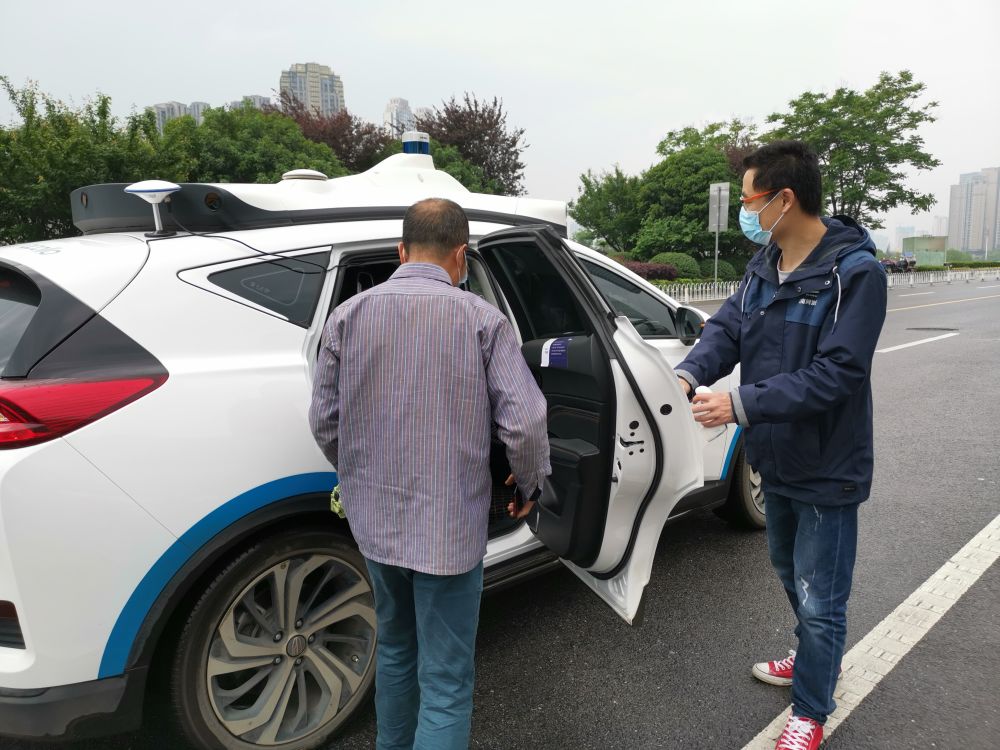 长沙梅溪湖国际文化艺术中心附近，一位市民在随车安全员引导下，准备登车试乘百度阿波罗自动驾驶出租车。新华社记者刘良恒 摄