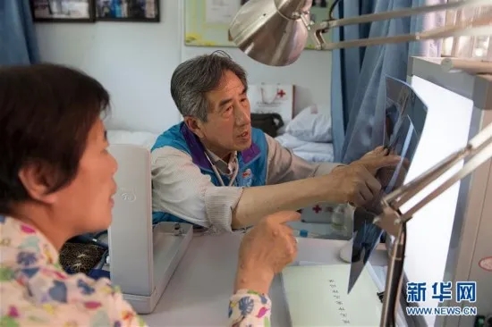 叶如陵在北京朝阳区香河园街道西坝河西里社区的叶如陵工作室为一位社区居民义务看病（2016年5月24日）。新华社记者 鞠焕宗 摄