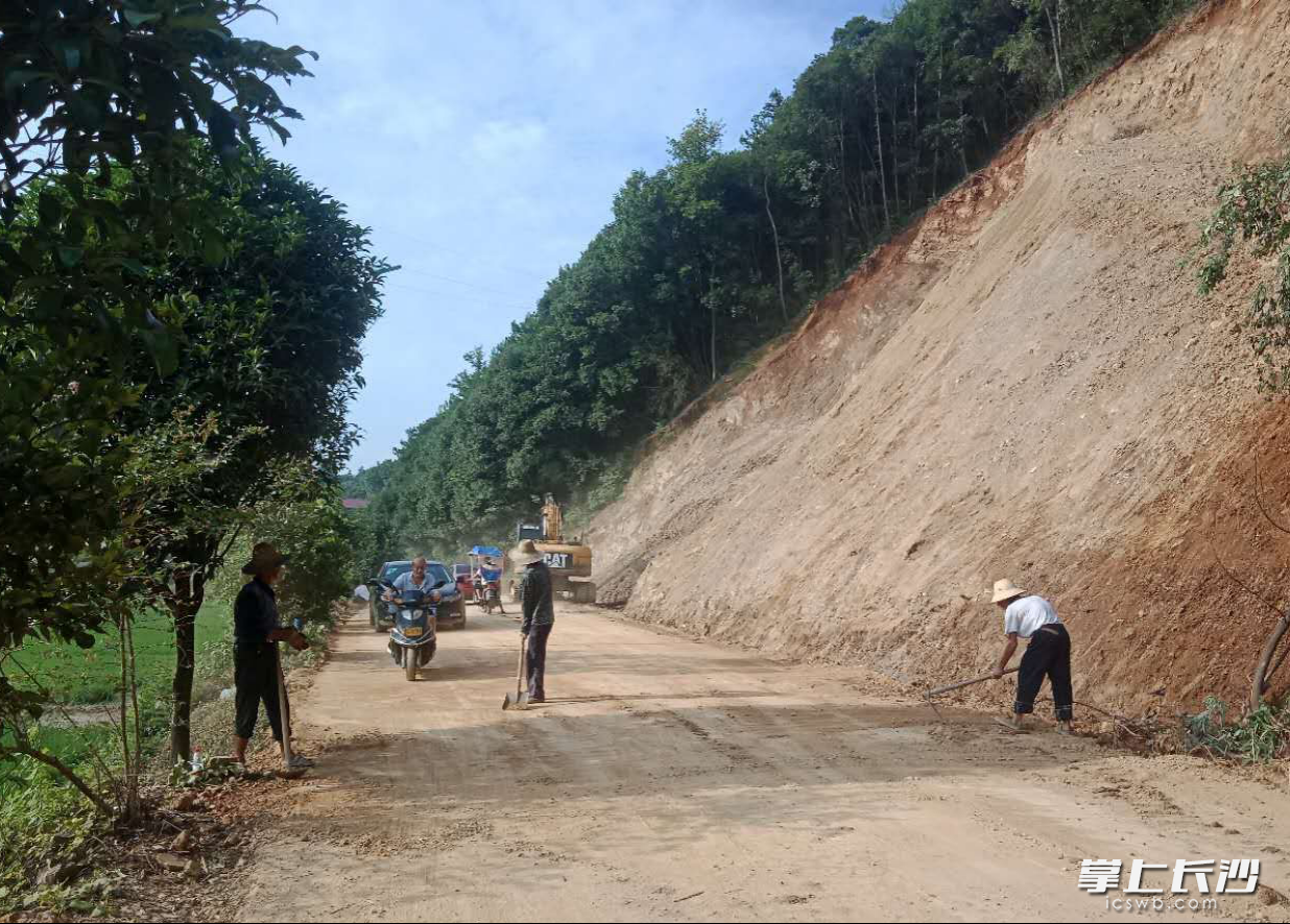 众人合力清扫高峰咀路段的路面障碍