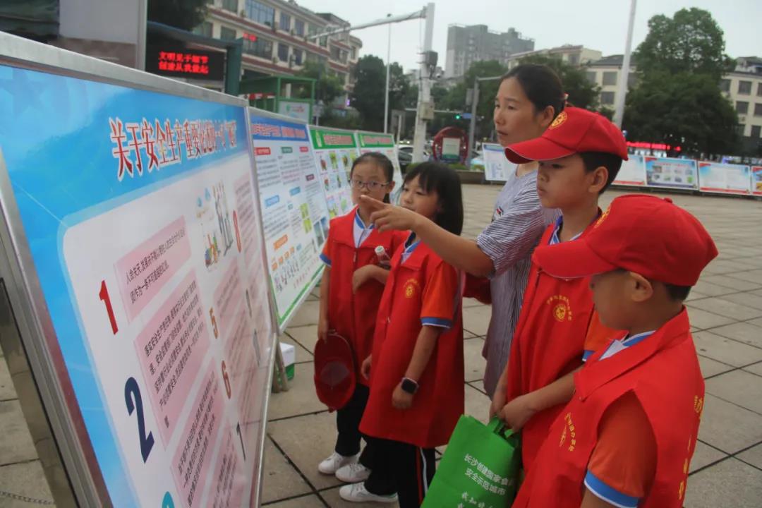 安全生产月咨询日活动现场，小小志愿者们正在向市民介绍安全常识