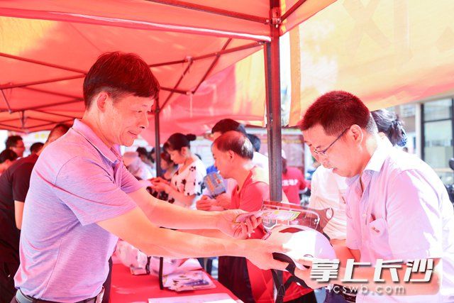 8月5日，长沙高新区雷锋街道举行一盔一带安全守护暨文明交通宣传活动。柯鸣 摄