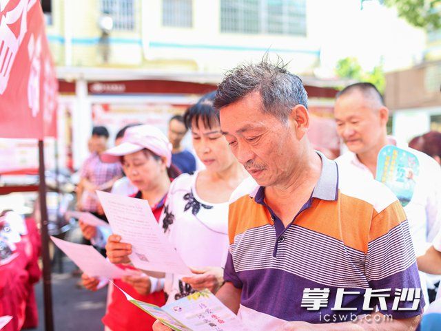 活动现场，麓谷居民认真阅读文明交通倡议书。柯鸣 摄