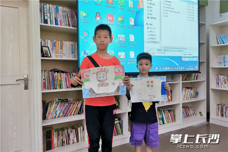 孩子们展示手绘作品。