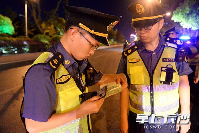 执法人员对相关证件进行检查。吴梦珊 摄