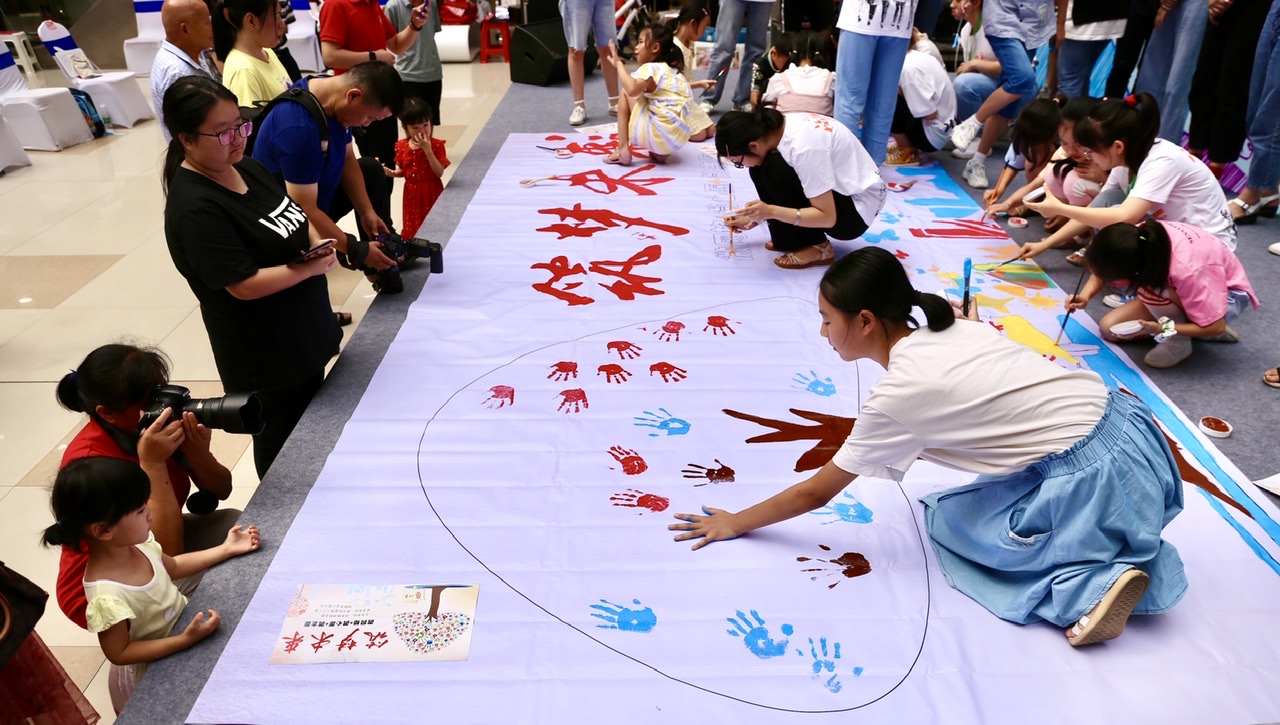 大学生和孩子们携手完成“筑梦未来”的长画，并按下手印。长沙晚报全媒体记者 颜开云 摄
