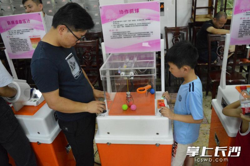 一位家长正和孩子体验协作抓球。