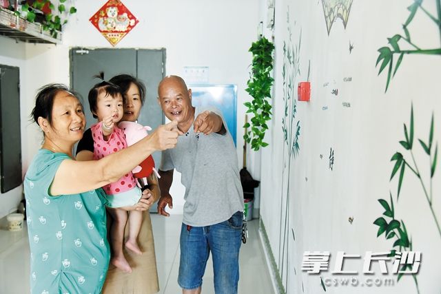 在爱晚花园小区改造后的楼梯间里，吴伟其（右一）一家其乐融融。黄荣佳 摄