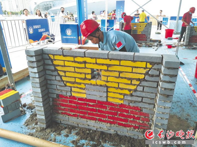 图为比赛现场，选手们在砖砌作品。