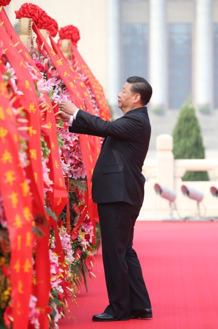 2017年9月30日上午，习近平等党和国家领导人出席烈士纪念日向人民英雄敬献花篮仪式。这是习近平整理花篮上的缎带。新华社记者 姚大伟 摄