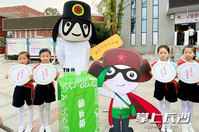 “雷锋侠”带着“节约箱”在雷锋第二小学的门口迎接同学们的到来。通讯员 供图