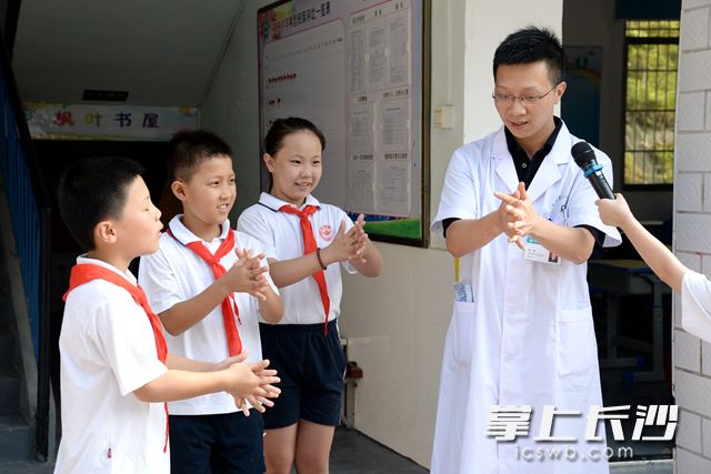枫树小学邀请湖南省抗击新冠先进个人谭鑫（右一）医生，普及科学有效的防疫技能。吴梦珊 摄