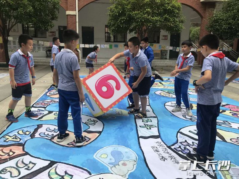 学生掷骰子，在校园里走“安全棋”。