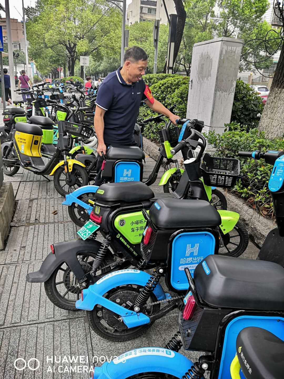 湖橡社区老党员在规范共享电动车停放。