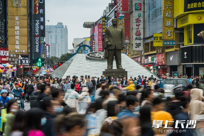 在解放路司门口人行通道，游客们通过红绿灯路口。