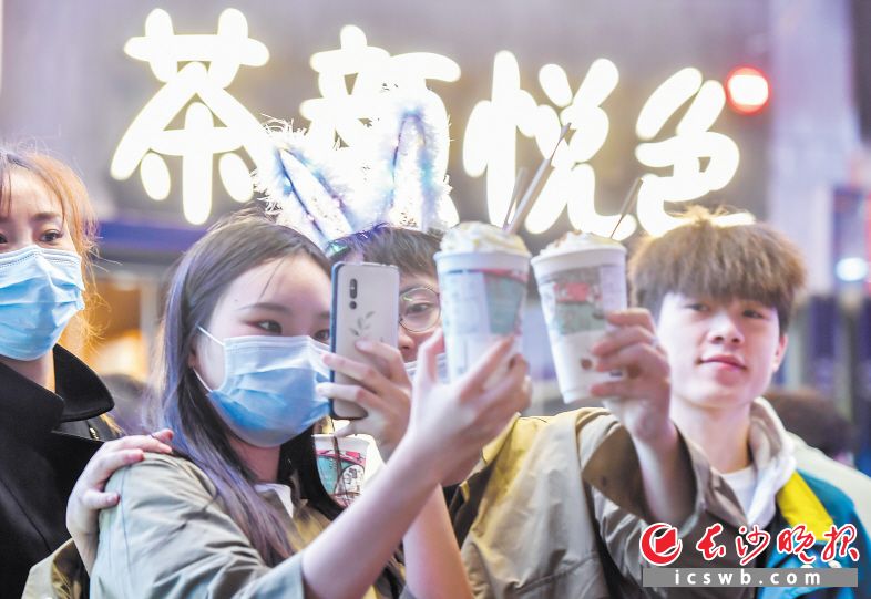 10月3日晚，几位游客排了很久的队终于买到想要的奶茶，拿到后先拍照发个朋友圈。