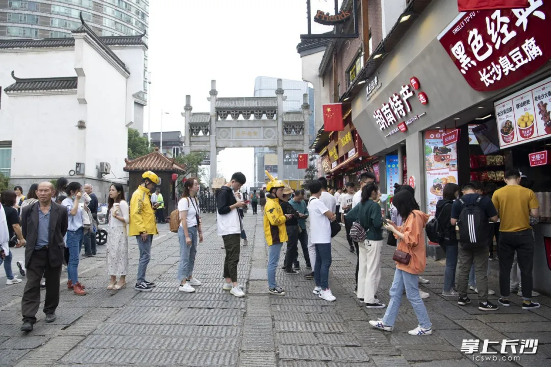 外卖小哥跑腿代排队方便了游客。