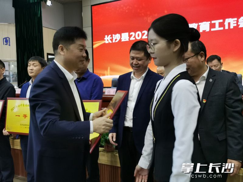 长沙县教育局局长陈卫球为获奖学校颁发奖牌。