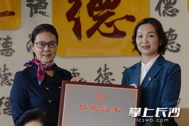 长沙市侨联主席陈慧（左）为麓景社区授予“长沙市侨胞之家”荣誉牌。