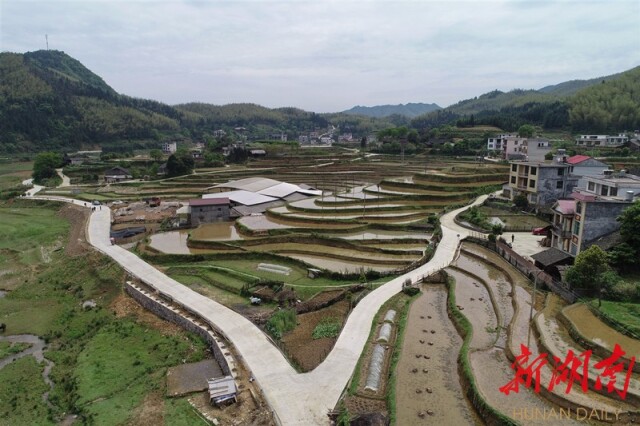 4月25日，新宁县金石镇罗源村，宽阔的村道。该村先后投入1200多万元完成进村主干道拓宽、罗源通崀山道路及部分通组道路硬化、护坡挡土墙修建、交通安全防护设施等项目。让昔日“水和泥”的路变水泥路。湖南日报·新湖南客户端记者 童迪 摄