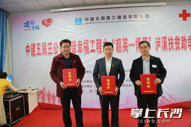 中建五局三公司党委书记、董事长陈勇与泸溪县红十字会常务副会长刘国富，永兴场完全小学校长杨金卫代表三方交换捐赠协议。