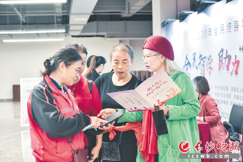 全民“学霸”向街坊们介绍如何用智能手机“智”学成才。 长沙晚报全媒体记者 李卓 摄