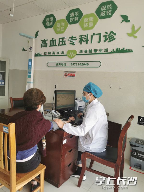 长沙县星沙医院高血压专科门诊医生为“慢性病自我管理小组”成员测量血压。