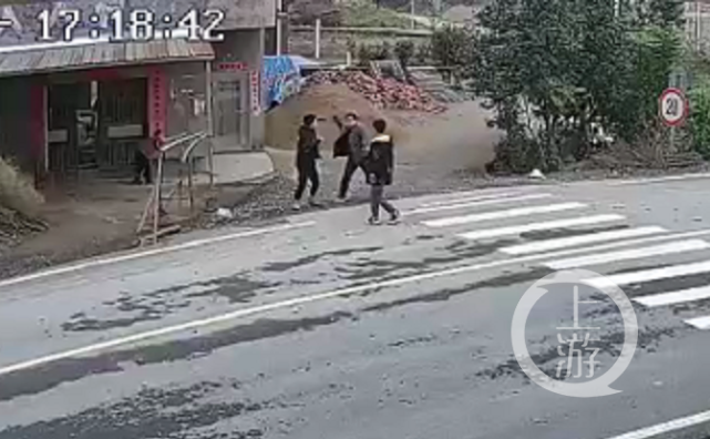 ▲马路边的施暴现场，右手臂扬起者为施暴家长。图片来源/视频截图