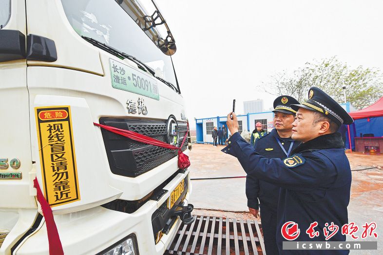 只要用手机“扫一扫”专用标识牌上的编码，渣土车的各类信息一目了然。王志伟 摄