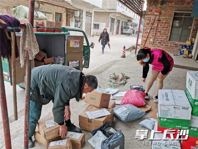 在宁乡市沙田乡石笋村，快递小哥按时将包裹快件送到超市，等候村民前来取件