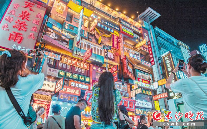 夜晚，游客们在步行街拍照打卡。