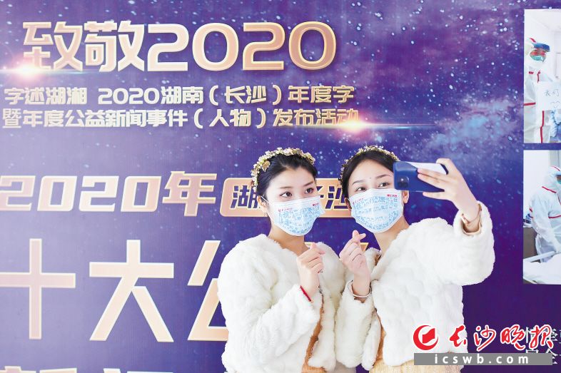 市民戴着写有“抗”“精”“高”“复”等年度字的创意口罩合影。长沙晚报全媒体记者 王志伟 摄