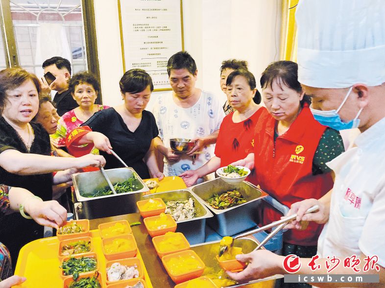 在西园北里，社区居家养老中心“老年餐桌”热腾腾的饭菜新鲜出锅，志愿者全程服务。（资料图片）
