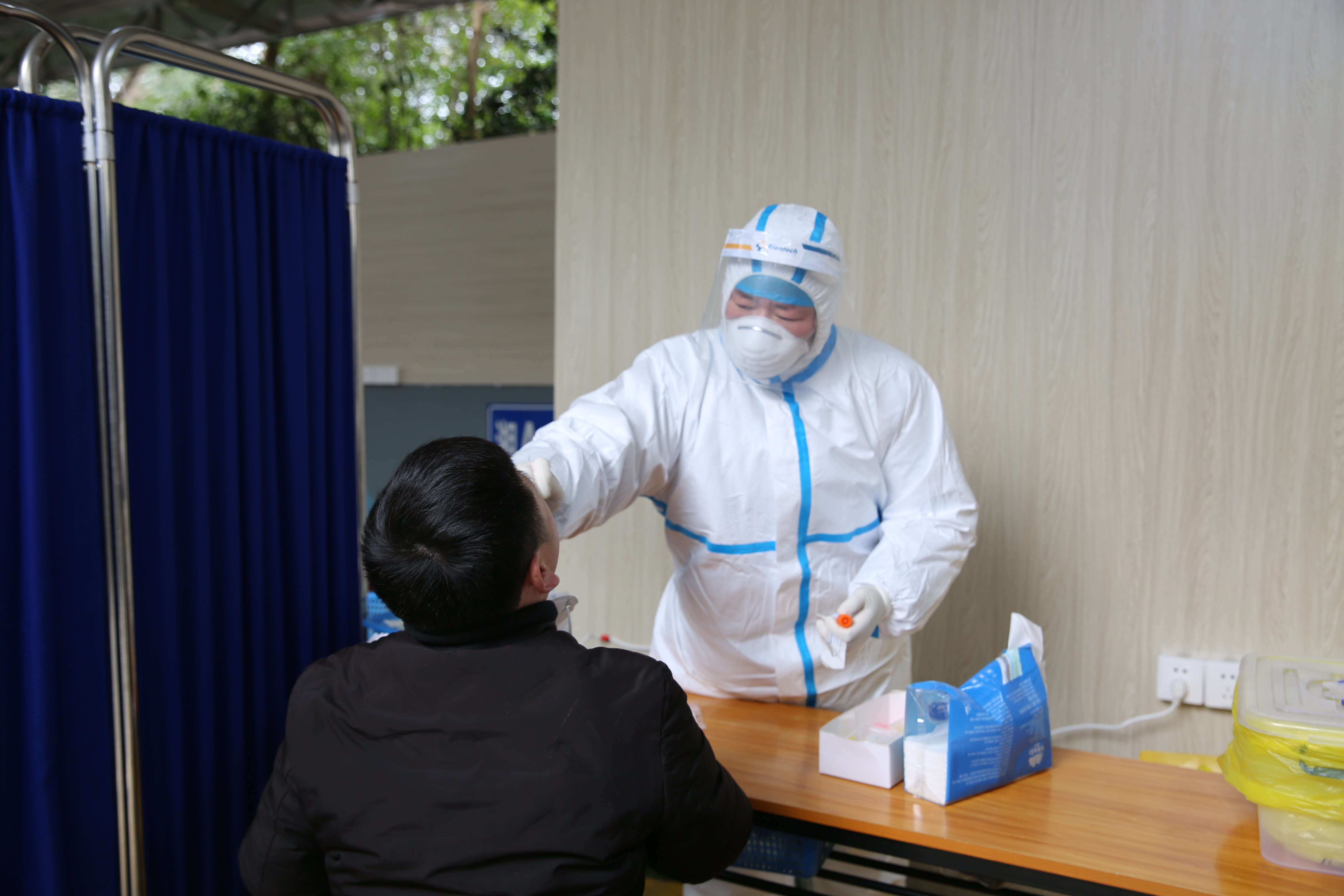 医生为打算返乡的人员开展核酸检测。粟青梅摄