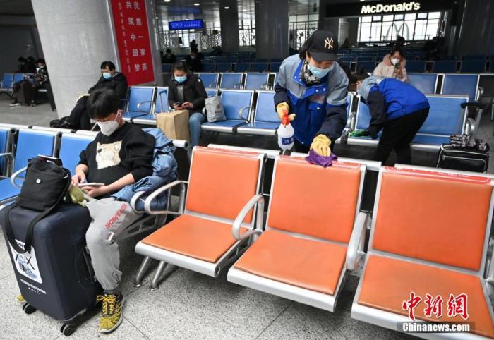 1月25日，呼和浩特火车站，工作人员在候车室内对座椅消毒。中新社记者 刘文华 摄