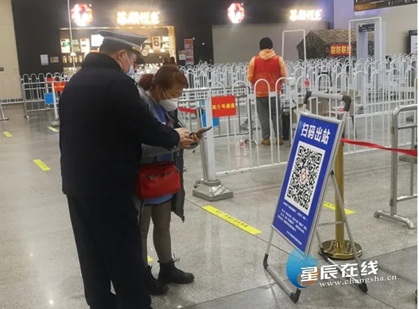 执法队员教旅客如何展示健康码。