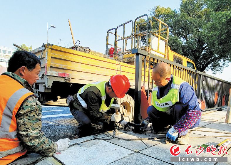 市政工人正在修补人行道上的破损路面，保障通行安全。吴峰荣 摄