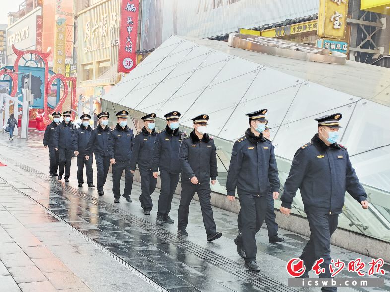 街面上，城管执法队员来回不间断巡查，发现市容问题第一时间进行处置。杜治锐 摄