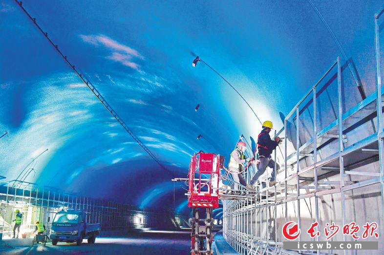 目前，位于湘江新区的麓景路南延线工程隧道顶部蓝天白云彩绘已喷涂完毕，正在进行防护板、机电安装等扫尾施工，预计今年6月完工。长沙晚报全媒体记者 王志伟 陈焕明 摄影报道