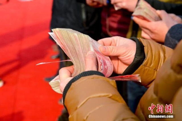 资料图：清点工资。 图片来源：视觉中国