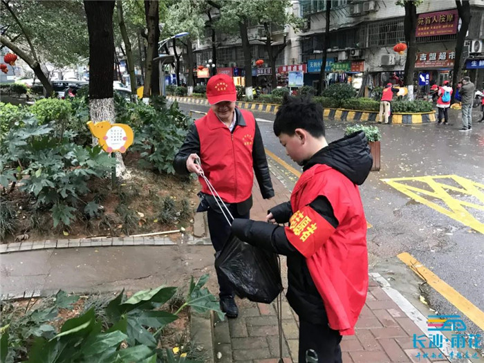 韶山路社区的党员干部、青年儿童主动参与，清理花坛里的枯枝烂叶。