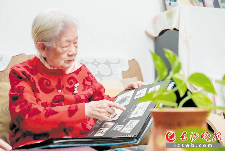2月28日，易晓东老人在家中翻看老照片，回忆起自己参军、入党、从事军事院校教学科研工作的难忘往事。长沙晚报全媒体记者 陈飞 摄