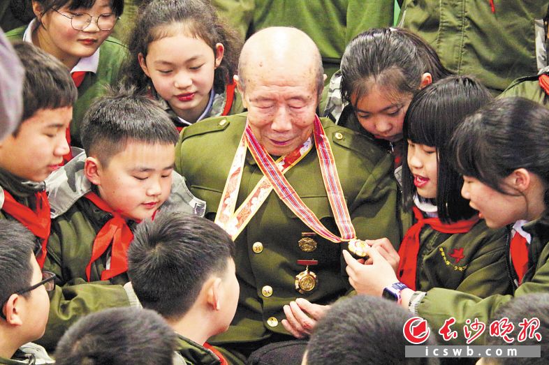 雨花区育新小学的孩子们紧紧围绕在英雄程英华老人身边，不肯离去。长沙晚报通讯员 李丹 摄
