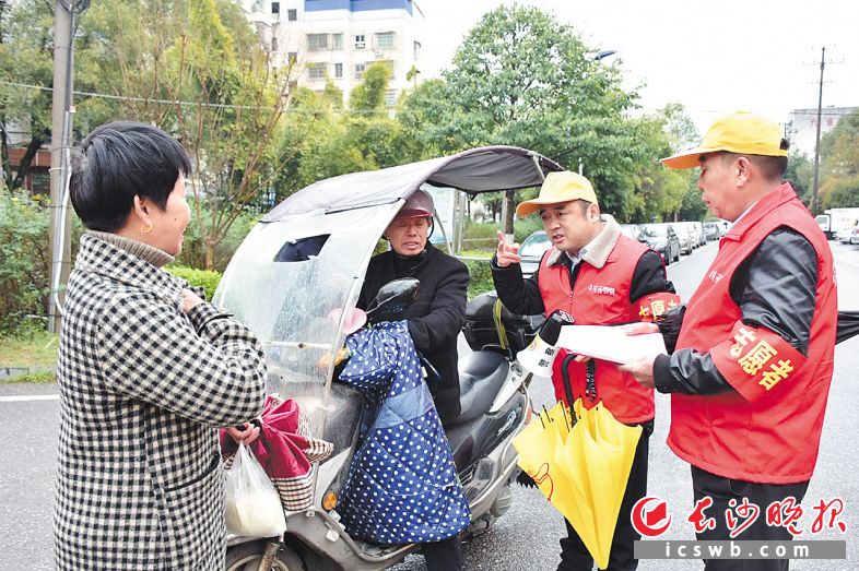 集里桥社区微网格长兼“黄帽子”志愿者上路劝导摩托车加装雨棚等违规行为。