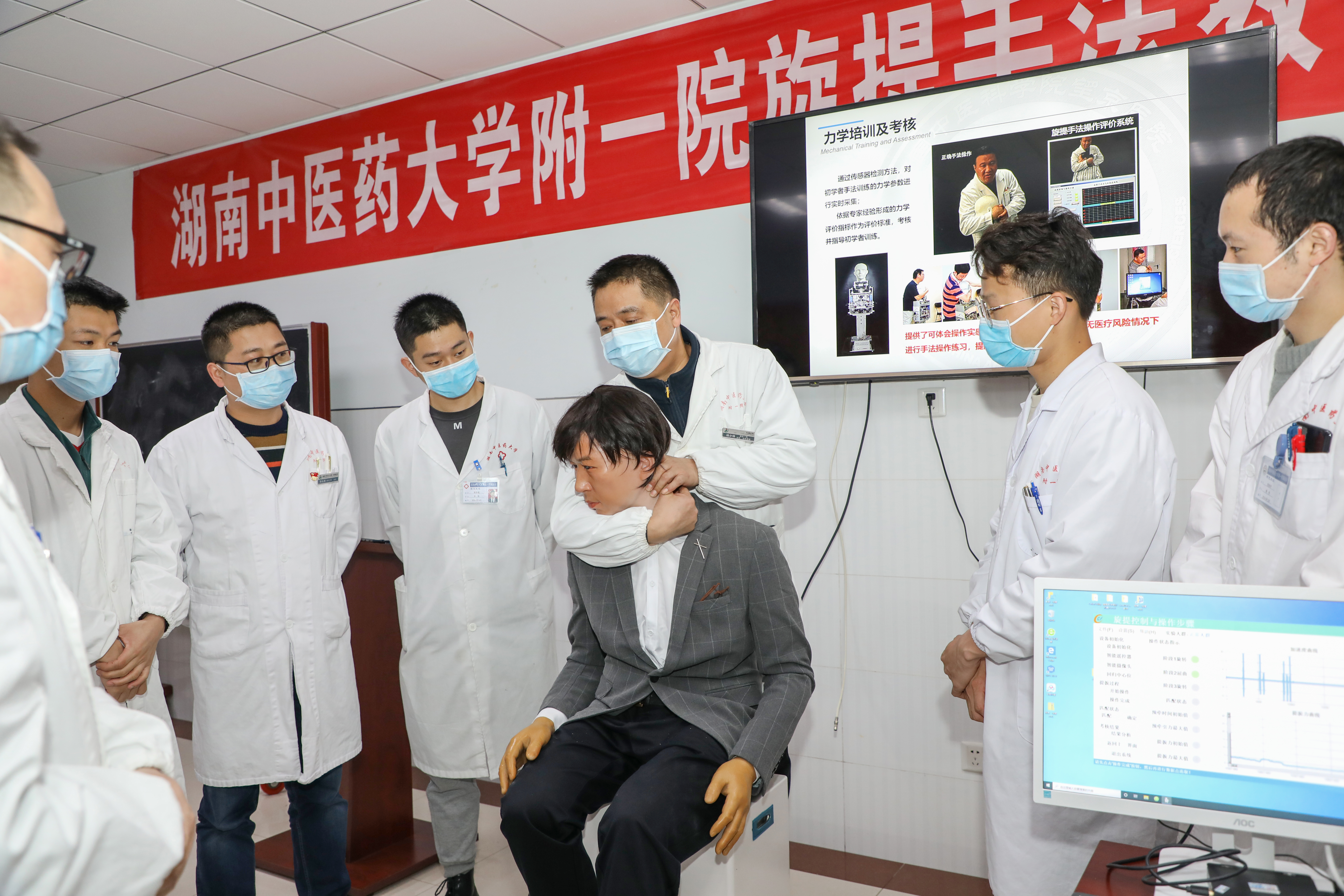坐着的西装革履的小伙子其实是机器人“患者”。