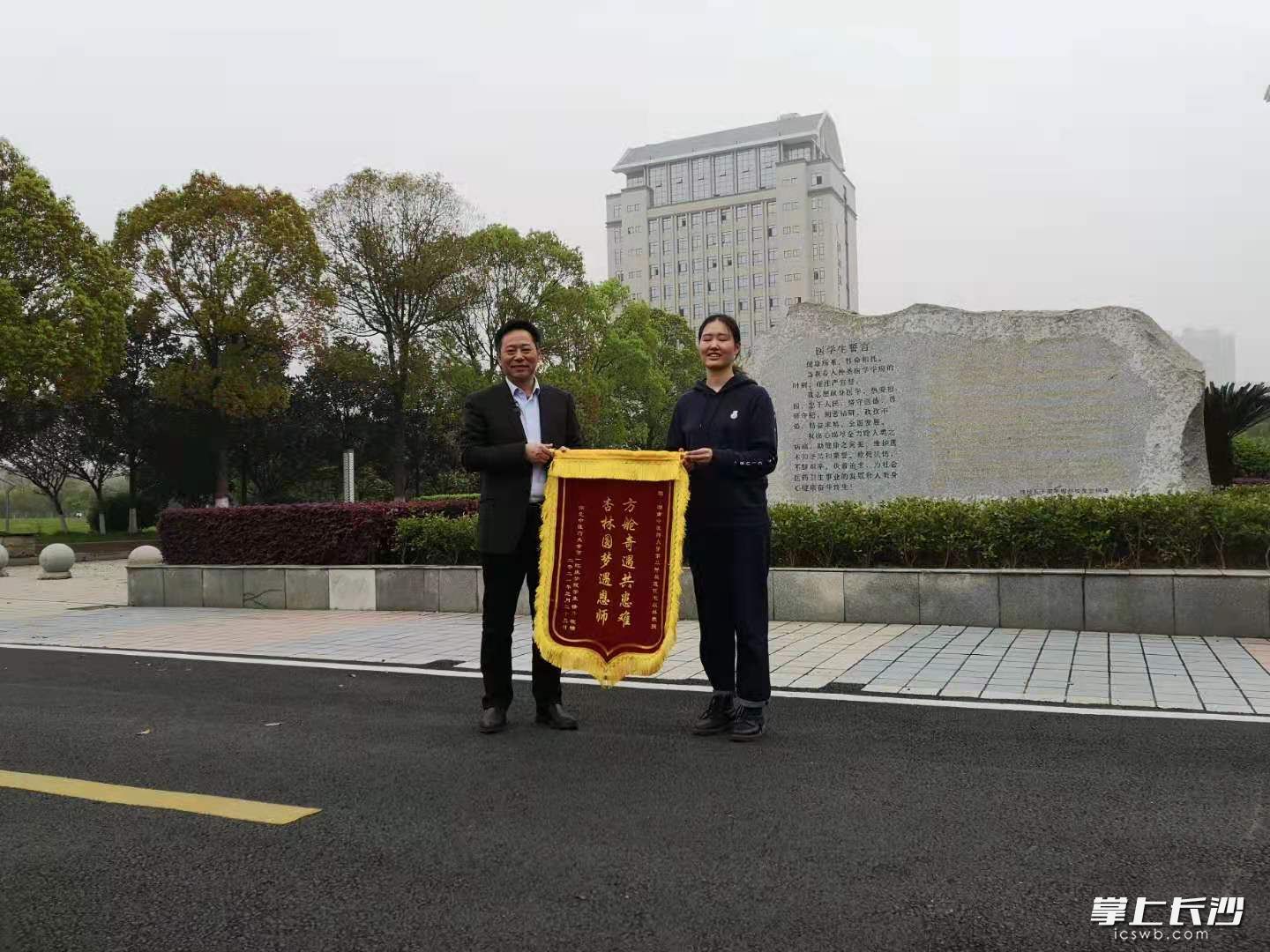 3月30日下午，徐丹得知拟被录取，将准备好的锦旗送给毛以林老师感谢其“治疗”与“鼓舞”。长沙晚报全媒体记者 杨蔚然 摄